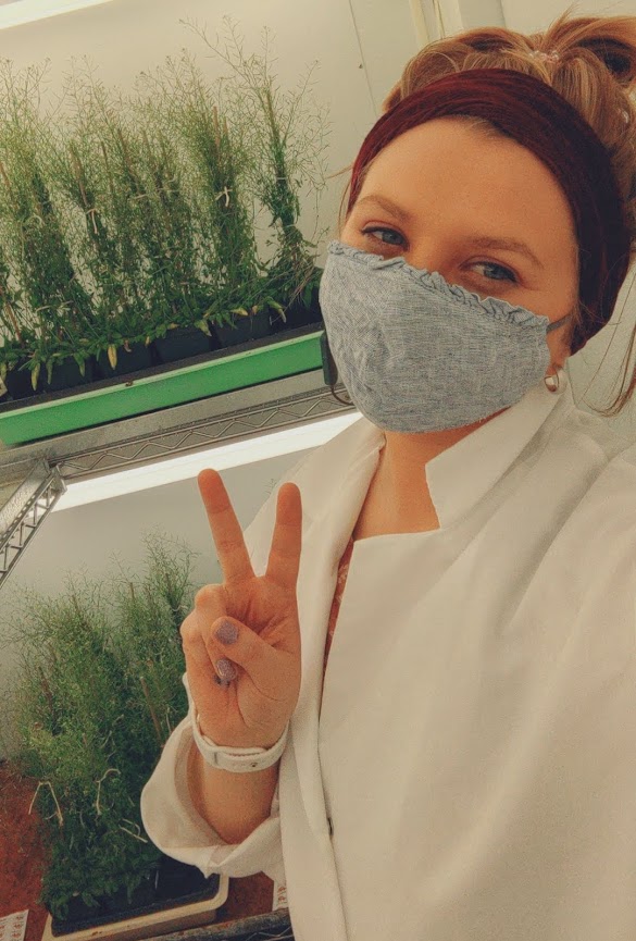 woman in lab coat with plants