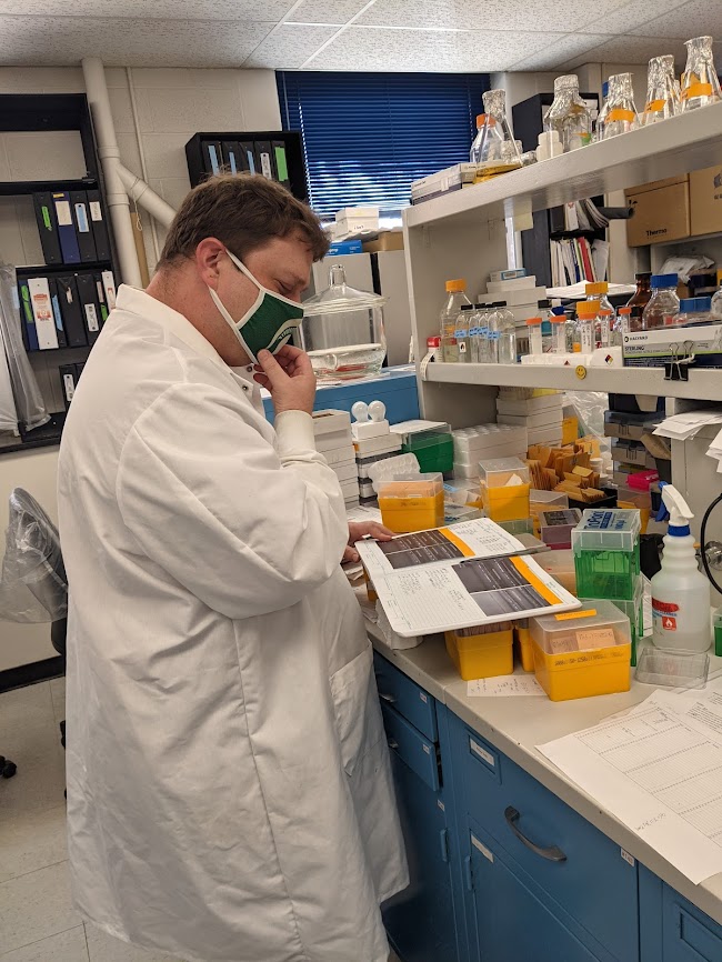 man studying notebook in lab